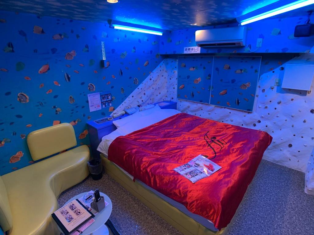 - une chambre avec un lit dans une pièce dotée d'un mur en pierre dans l'établissement 愛愛賓館 Adult Only, à Wada