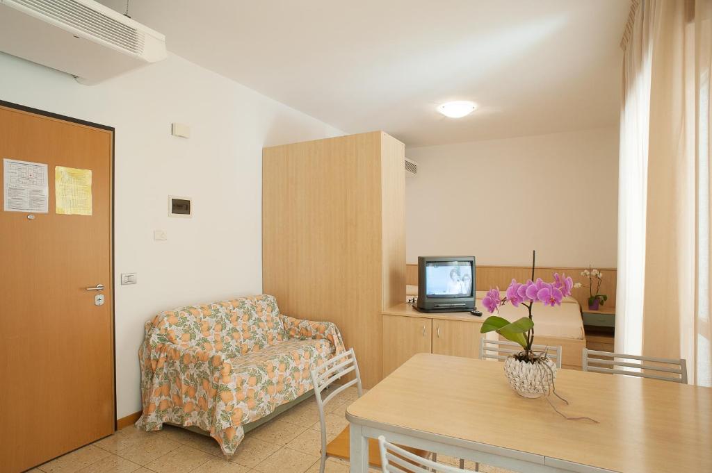 un salon avec une chaise et une télévision dans l'établissement Residence Cà D'oro, à Lido di Jesolo