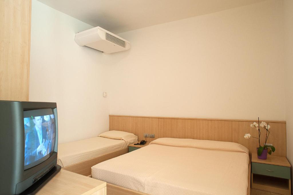 Cette chambre d'hôtel dispose d'une télévision et d'un lit. dans l'établissement Residence Cà D'oro, à Lido di Jesolo