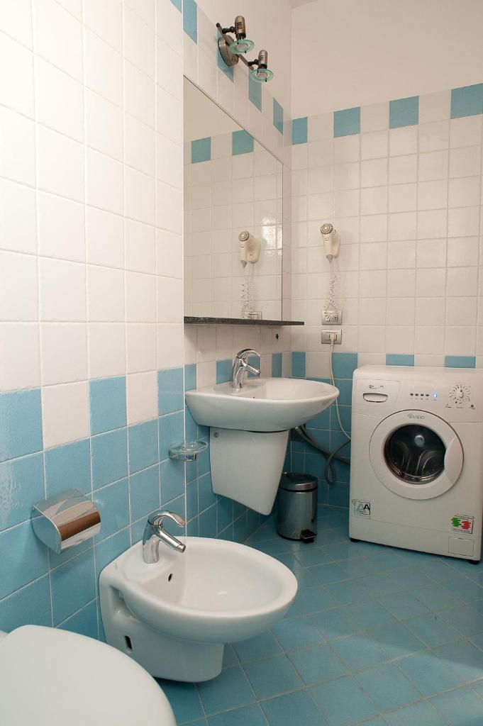 une salle de bain avec un lavabo et une machine à laver dans l'établissement Residence Cà D'oro, à Lido di Jesolo 34 autres photos