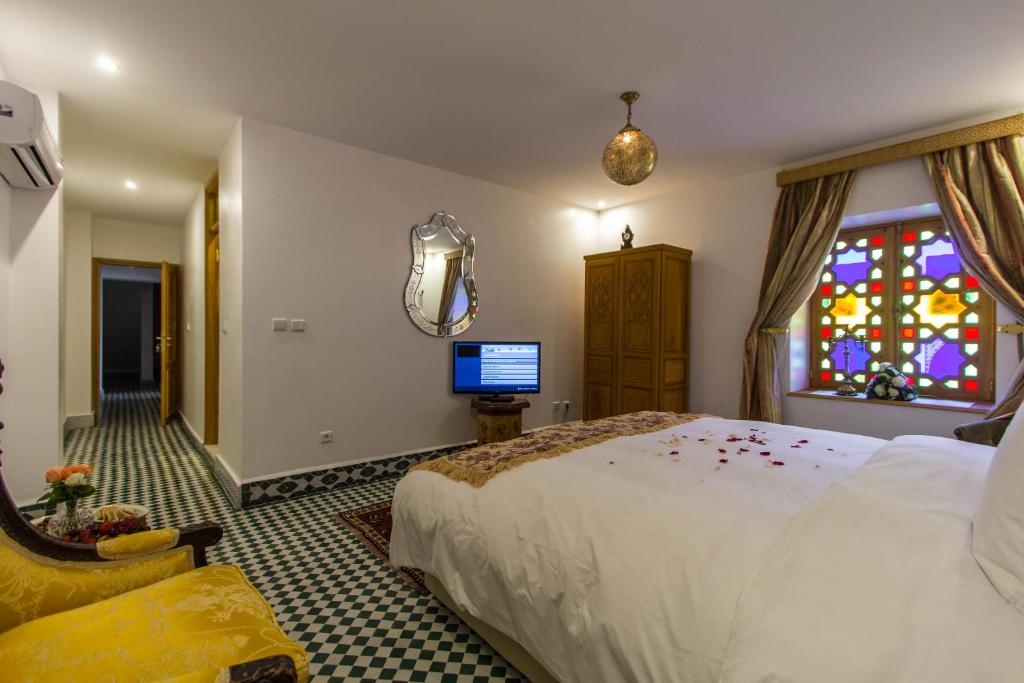 une chambre avec un lit et un vitrail dans l'établissement Riad Amor - Suite & Spa, à Fès