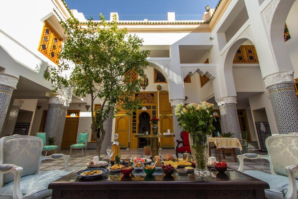 un salon avec une table avec de la nourriture dessus dans l'établissement Riad Amor - Suite & Spa, à Fès