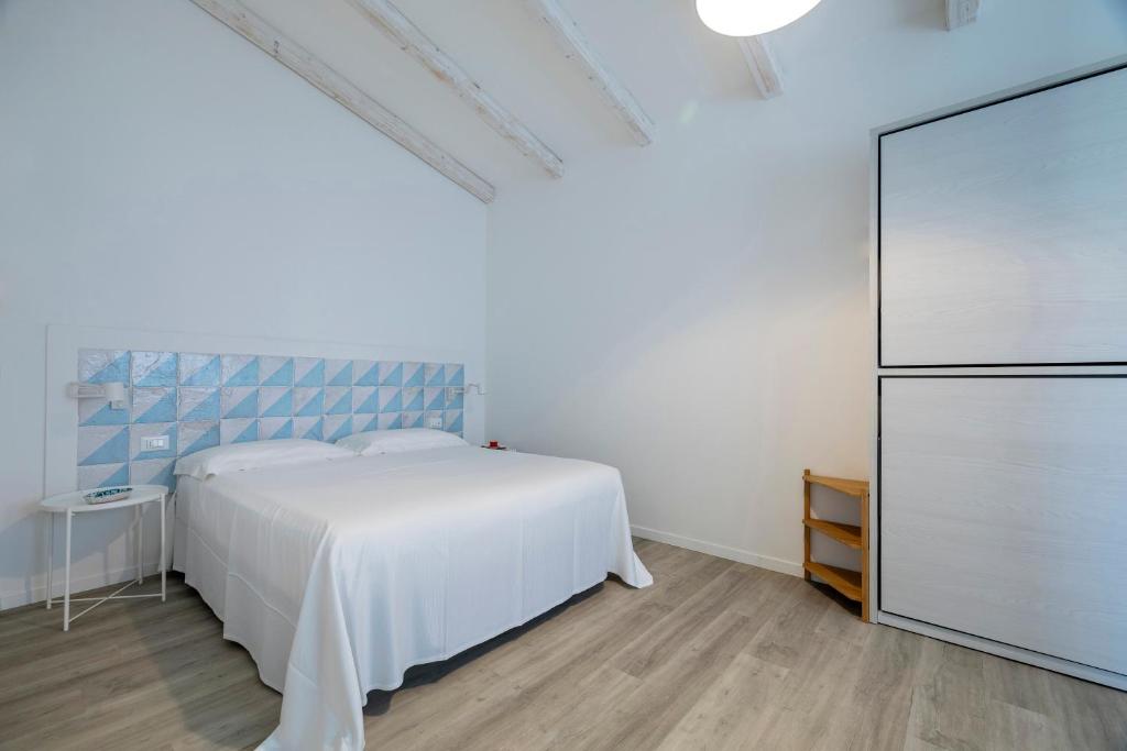 une chambre avec un lit blanc et une commode dans l'établissement Casale la Macina Residence Scopello, à Scopello