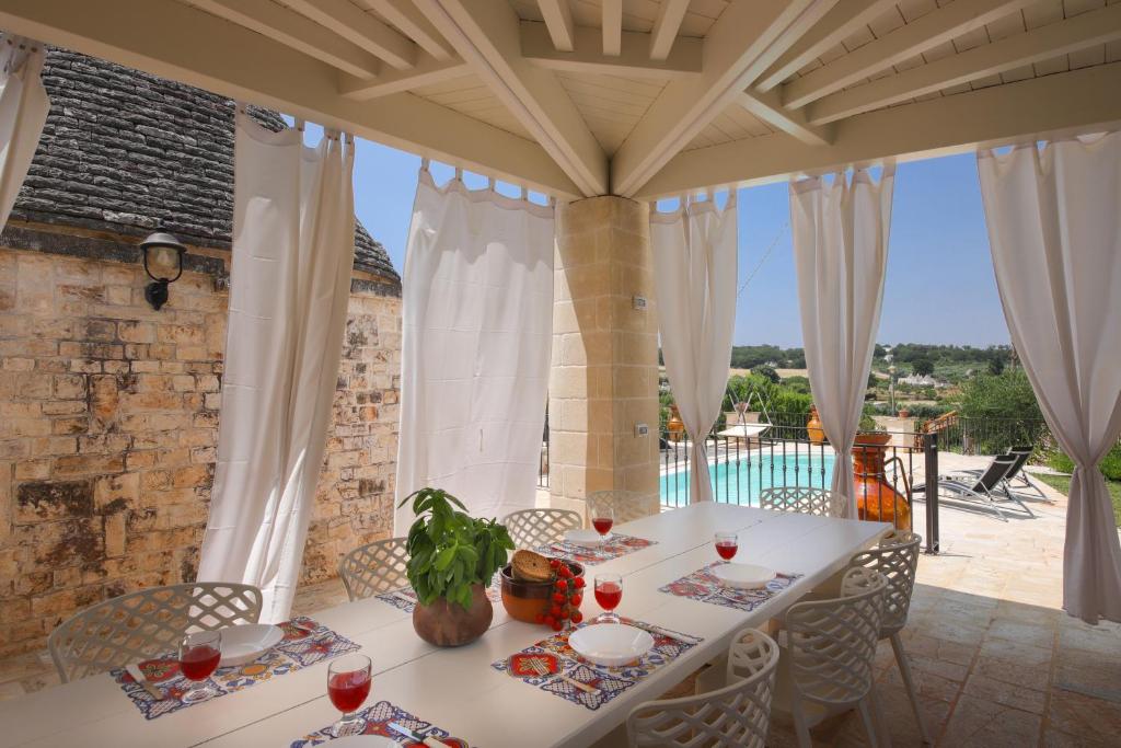 - une salle à manger avec une table et des verres à vin dans l'établissement Trulli del Carrubo by Apulia Hospitality, à Locorotondo