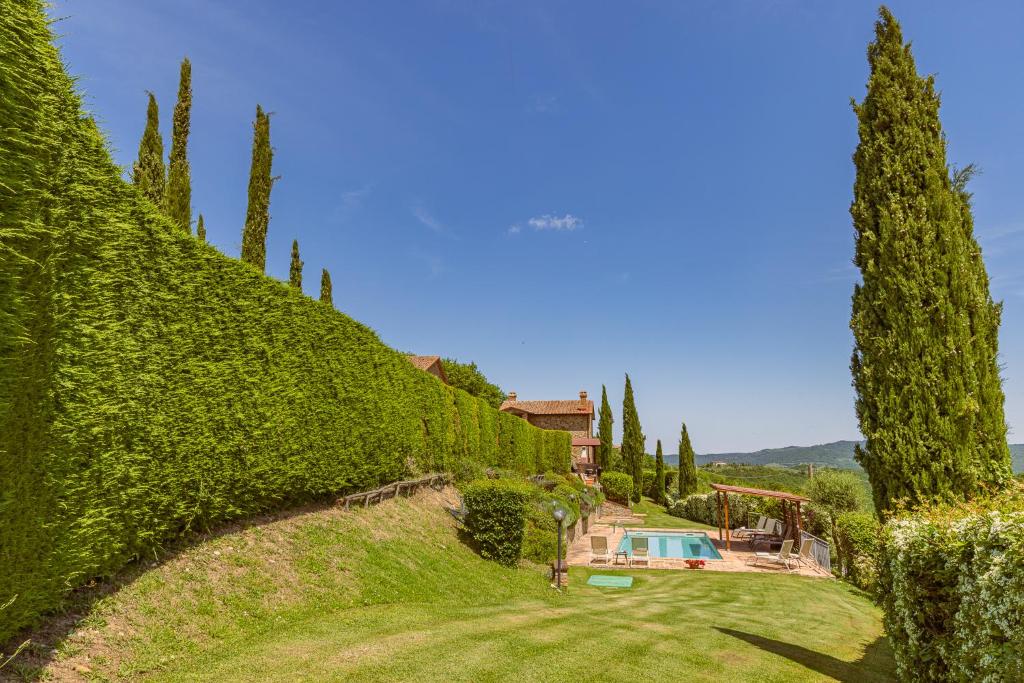 une colline couverte de lierre avec une maison et une piscine dans l'établissement Casa Baiocco, à Città della Pieve