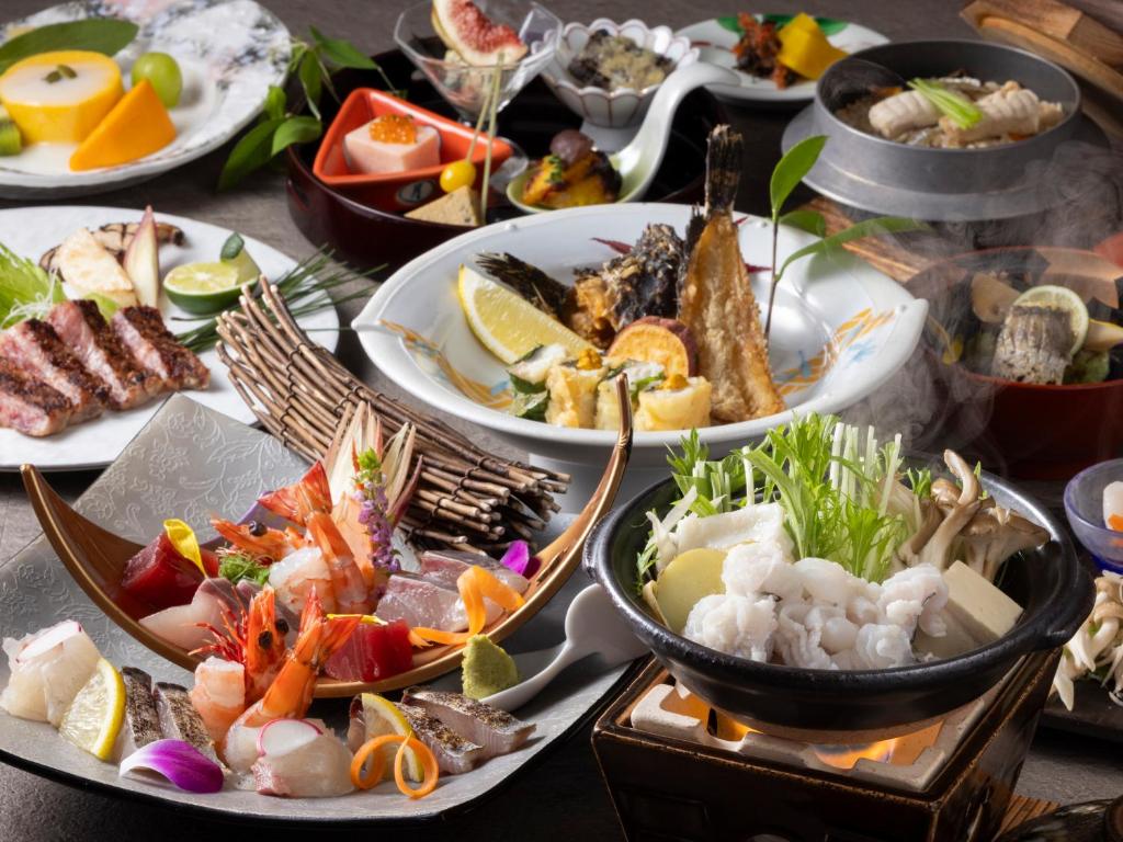 une table pleine d'assiettes de nourriture sur une table dans l'établissement KAMENOI HOTEL Kanonji, à Kanonji