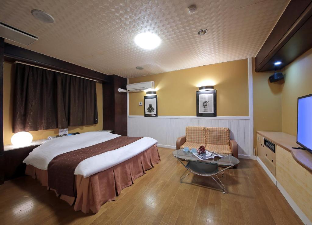 une chambre d'hôtel avec un lit et une télévision dans l'établissement Hotel Mio Resort ( Adult Only), à Yokkaichi