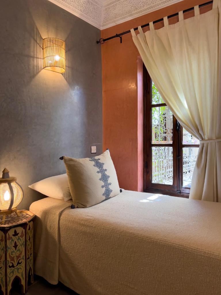 - une chambre avec un lit doté d'une fenêtre et d'une lampe dans l'établissement Monriad, à Marrakech