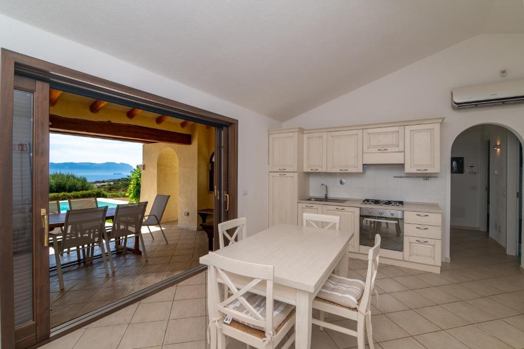 une cuisine et une salle à manger avec une table et des chaises dans l'établissement Villa Daniela, à Olbia