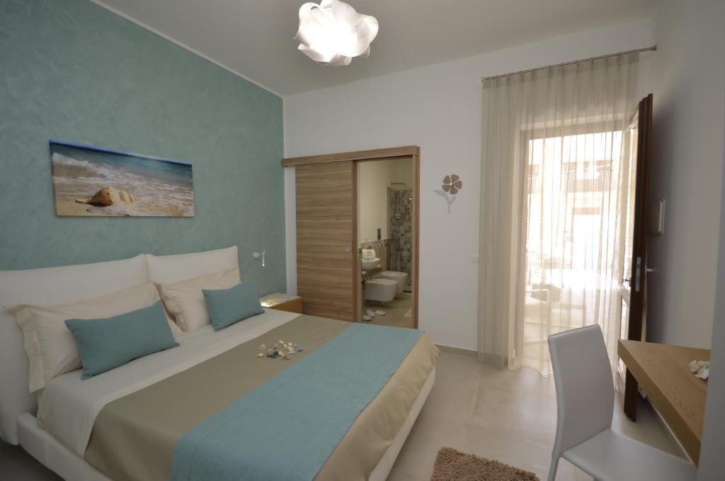 une chambre avec un grand lit et une salle de bain dans l'établissement Ciuri Di Mari, à San Vito Lo Capo