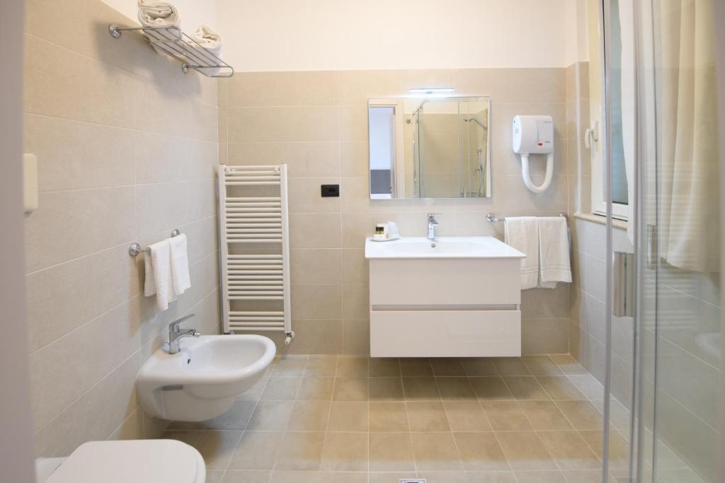 une salle de bain blanche avec un lavabo et des toilettes dans l'établissement Hotel Graziella, à Martinsicuro 10 autres photos