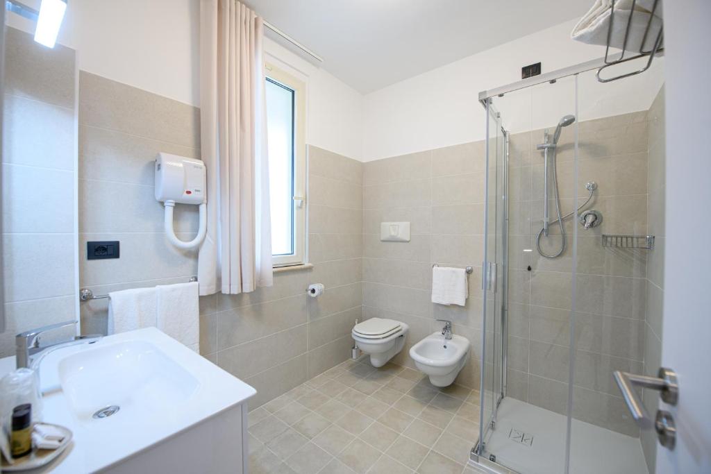 une salle de bain avec une douche, des toilettes et un lavabo dans l'établissement Hotel Graziella, à Martinsicuro