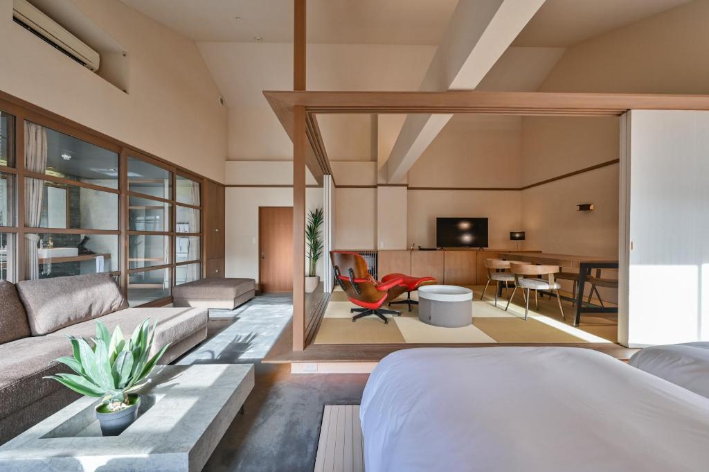 une chambre avec un lit et un salon dans l'établissement Ryokan Yoshidaya, à Ureshino