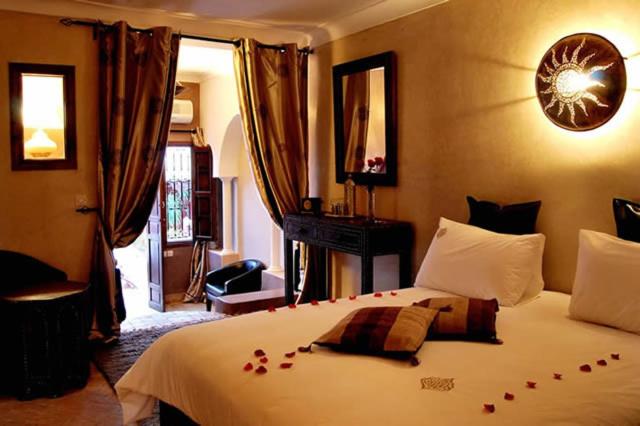 - une chambre avec un lit orné de roses rouges dans l'établissement Riad D'Airain, à Marrakech