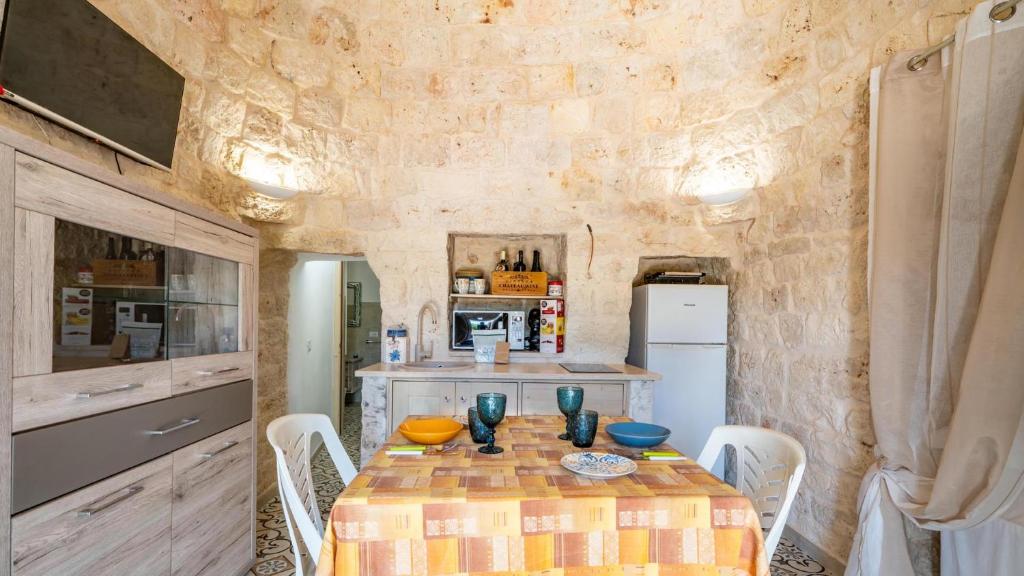 une cuisine avec une table et des chaises dans une pièce dans l'établissement Villa Frarogi by Rentbeat, à Ostuni