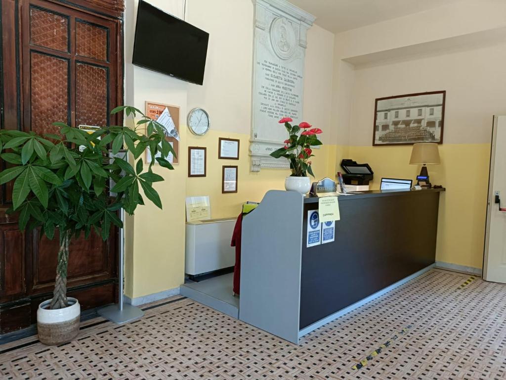 un bureau avec un comptoir d'accueil et une plante en pot dans l'établissement Sacro Cuore Hotel, à Marina di Massa 3 autres photos