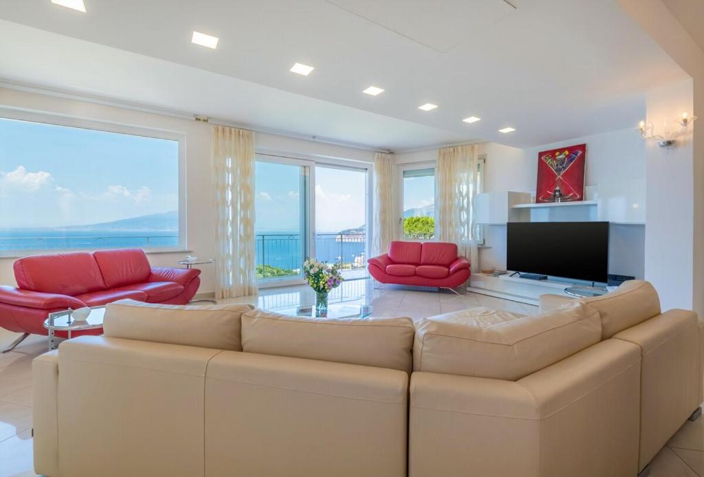 - un salon avec un grand canapé et des fauteuils rouges dans l'établissement Casa Angelica, à Sorrente