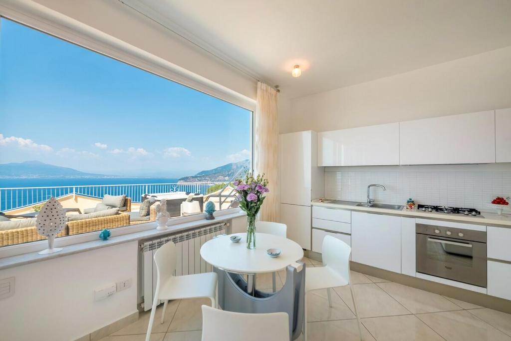 une cuisine avec une table et une grande fenêtre dans l'établissement Casa Angelica, à Sorrente