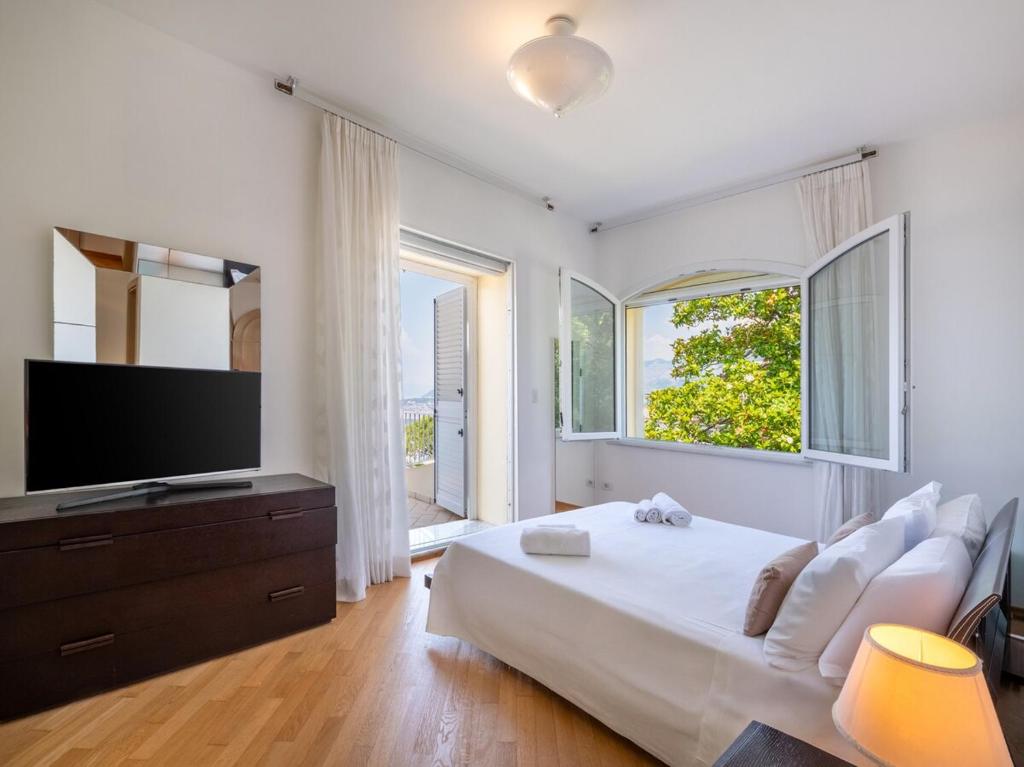 une chambre avec un grand lit et une télévision à écran plat dans l'établissement Casa Angelica, à Sorrente