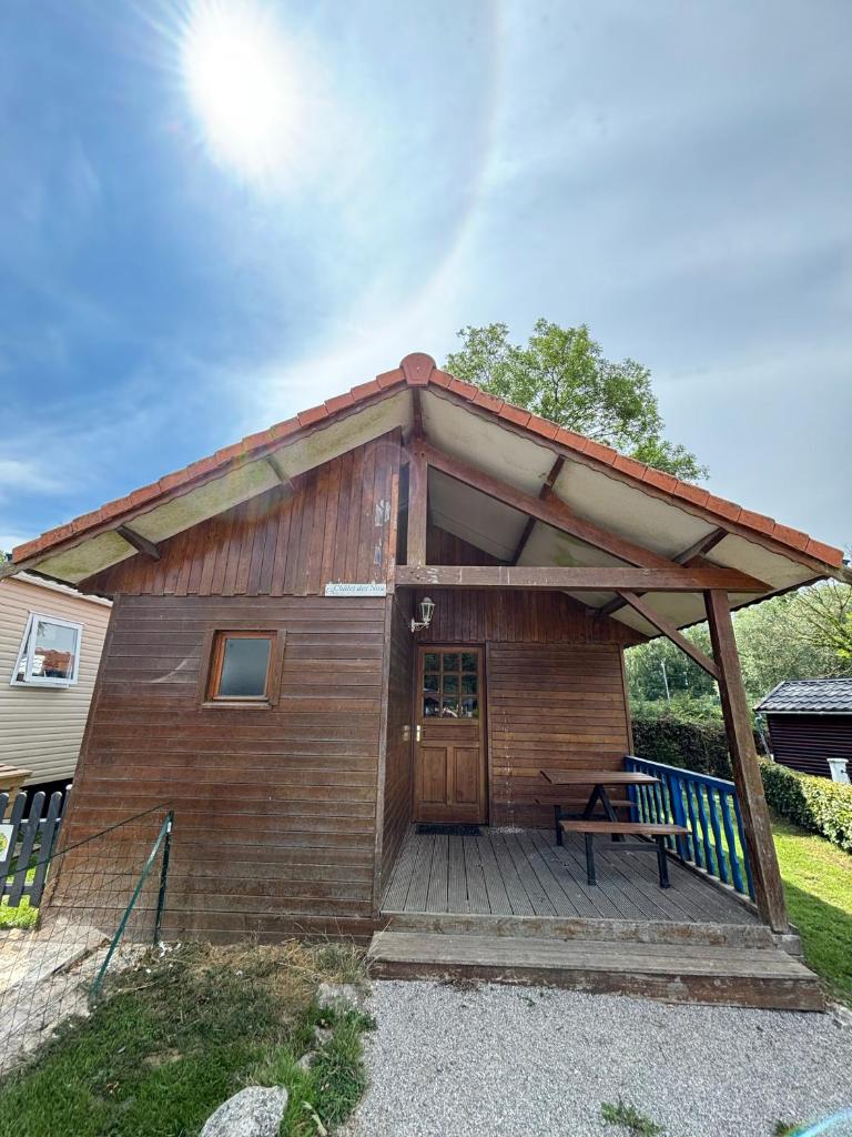 une petite cabane en bois avec un banc sur une terrasse dans l'établissement Camping La Tentation, à Renty