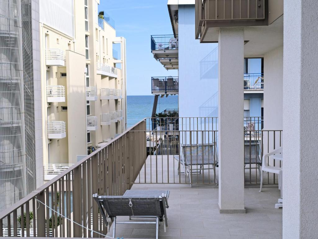un balcon avec un banc et l'océan en arrière-plan dans l'établissement Hotel Midi, à Lido di Jesolo
