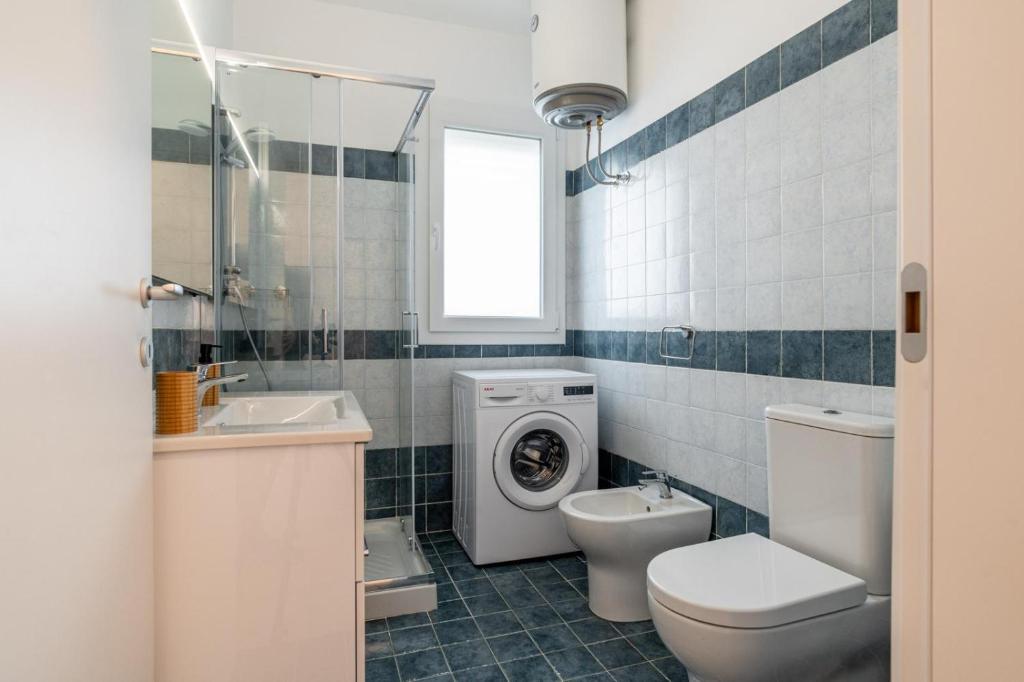 une salle de bain avec un lavabo et une machine à laver dans l'établissement Villademar lunarossa, à Marzamemi