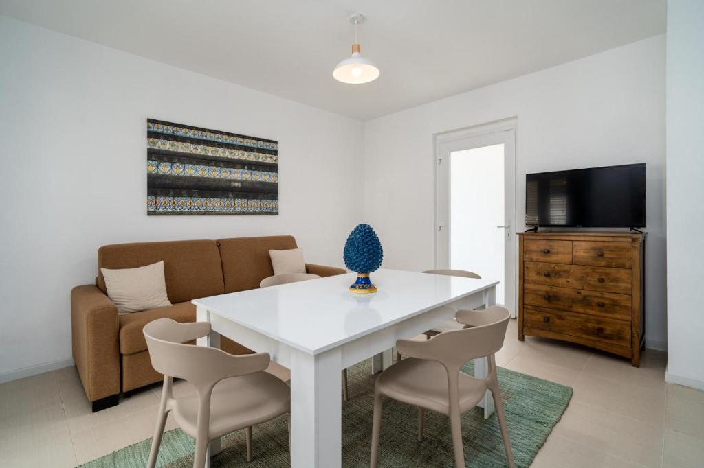 un salon avec une table et des chaises blanches dans l'établissement Villademar lunarossa, à Marzamemi