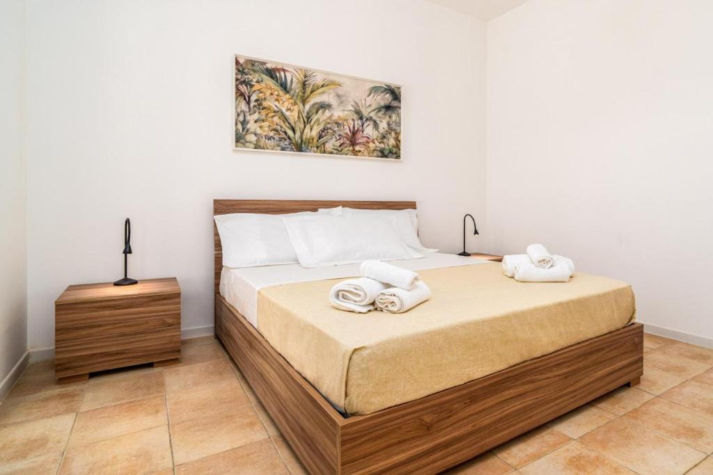 une chambre avec un lit avec deux serviettes dessus dans l'établissement Villademar lunarossa, à Marzamemi 18 autres photos