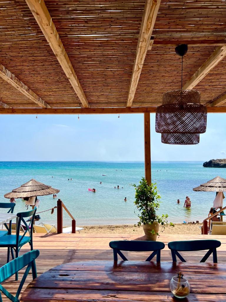 - une plage avec des chaises et des personnes dans l'eau dans l'établissement Villademar lunarossa, à Marzamemi