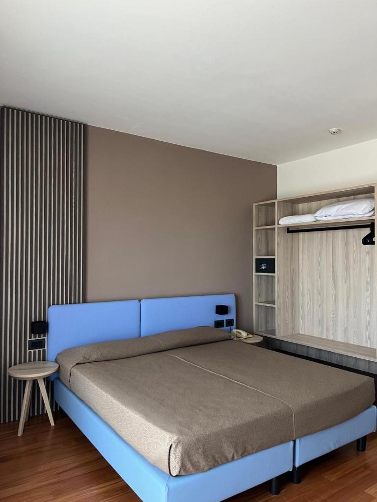 - une chambre avec un lit bleu dans l'établissement Hotel Italy, à Bibione