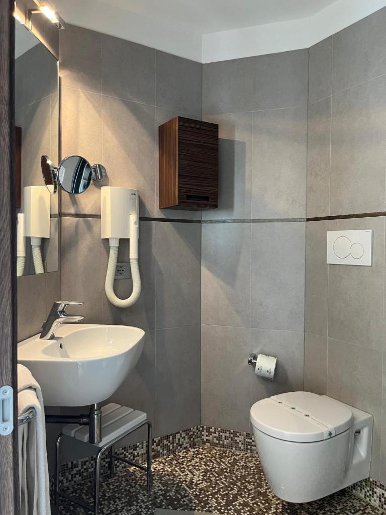 une salle de bain avec des toilettes blanches et un lavabo dans l'établissement Hotel Italy, à Bibione