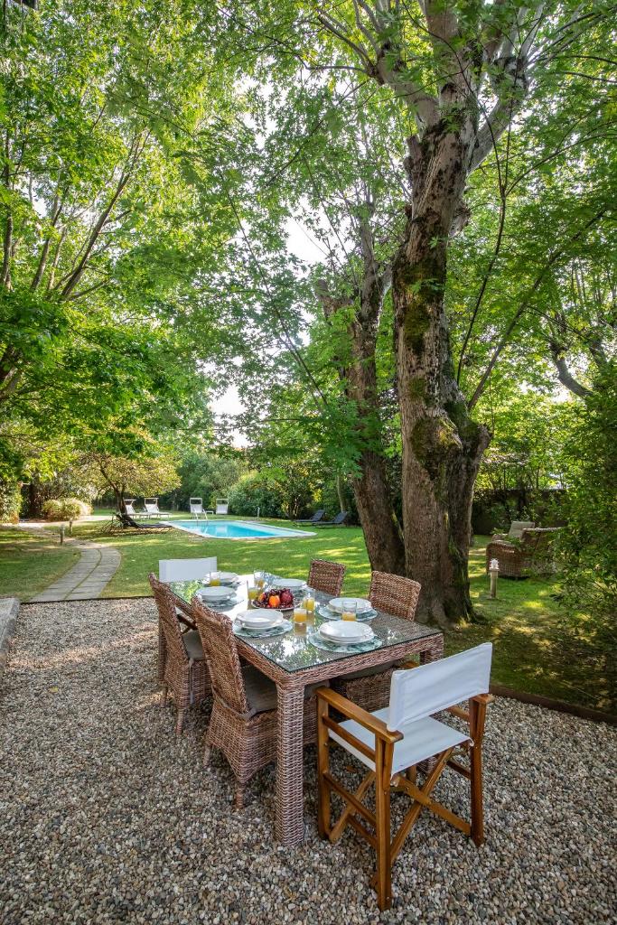 - une table et des chaises dans une cour avec une piscine dans l'établissement Villa Giardino Lucca heated pool, 2 miles Lucca, à Capannori