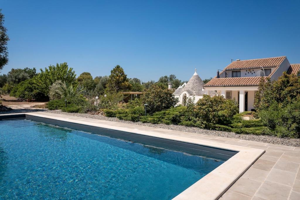 une piscine devant une maison dans l'établissement Villa Trullo Cantaluna - Esclusiva villa con trullo e piscina privata, à Ceglie Messapica