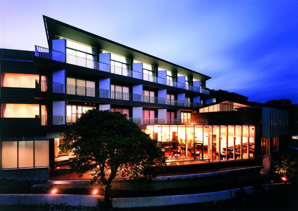 un bâtiment avec beaucoup de fenêtres la nuit dans l'établissement Atami Tensui, à Atami