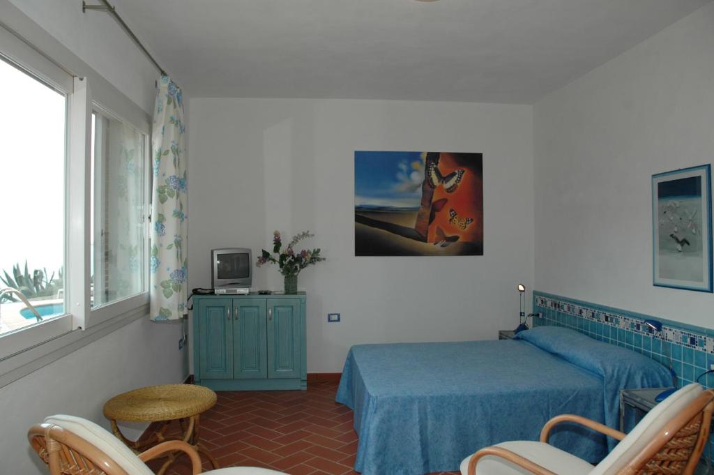 une chambre avec deux lits et une table et des chaises dans l'établissement Residence Cala dei Peducelli, à Capoliveri 49 autres photos