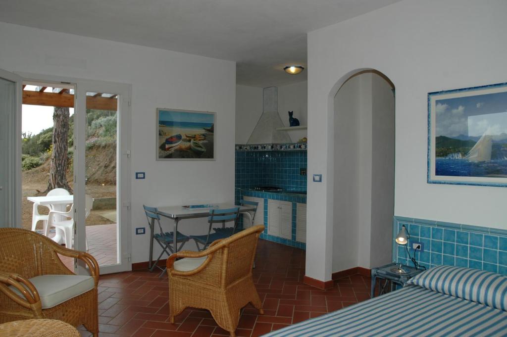 un salon avec un lit, une table et des chaises dans l'établissement Residence Cala dei Peducelli, à Capoliveri