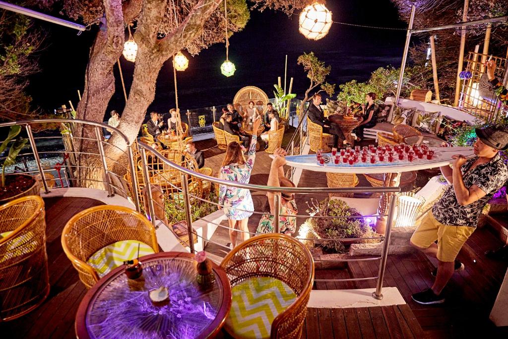 un groupe de personnes debout sur un pont dans l'établissement Forte Village Resort - Villa Del Parco & Spa, à Santa Margherita di Pula