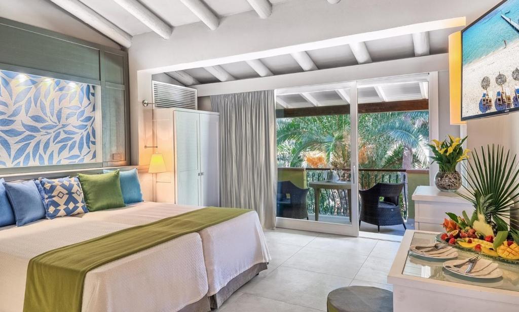 une chambre avec un grand lit et une cheminée dans l'établissement Forte Village Resort - Pineta, à Santa Margherita di Pula