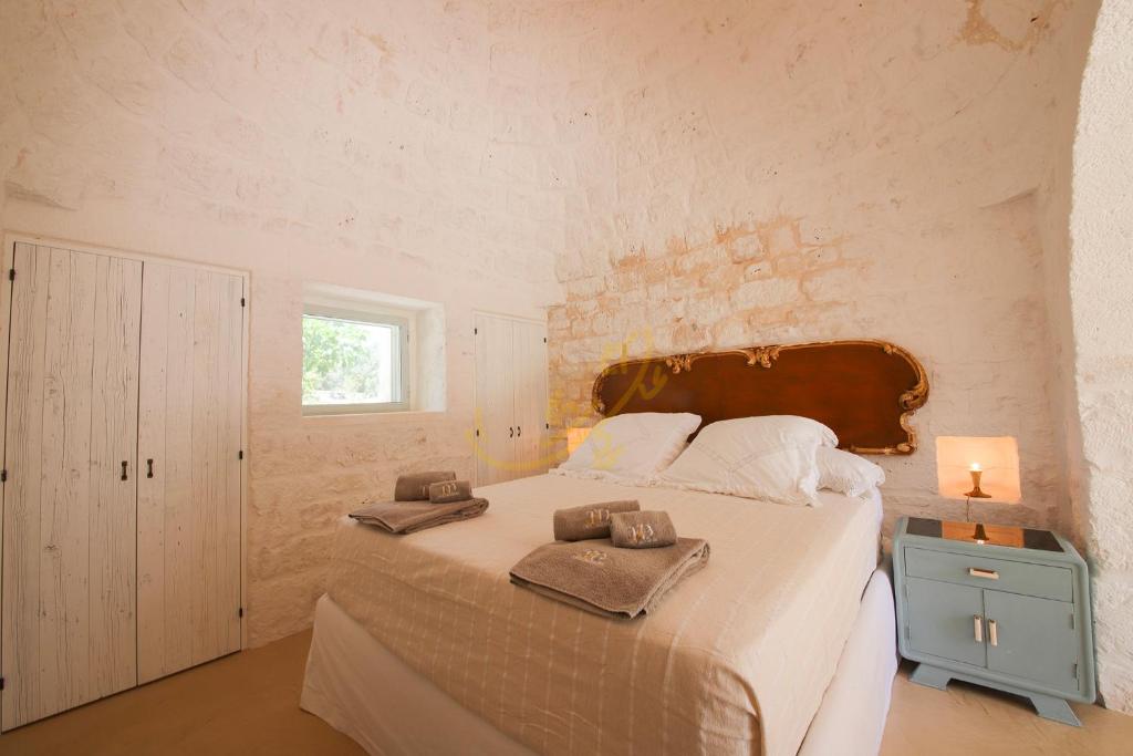 une chambre avec un grand lit avec des serviettes dessus dans l'établissement TD Trulli Vittoriani Charme and Pure Nature w pool, à Ostuni