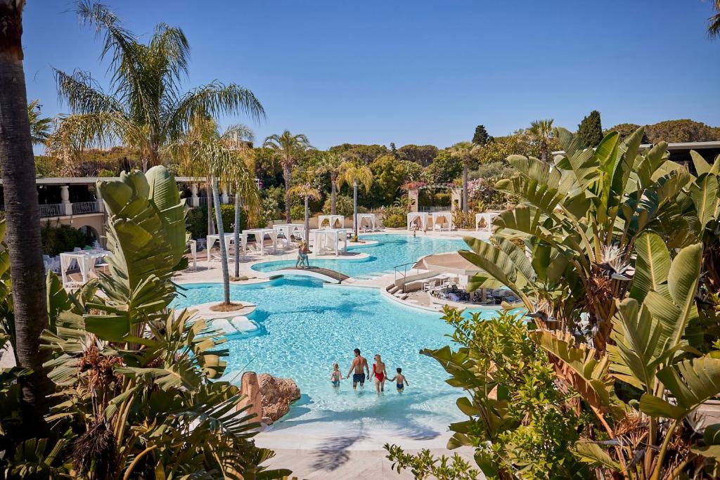 un groupe de personnes dans une piscine d'un complexe hôtelier dans l'établissement Forte Village Resort - Il Borgo, à Santa Margherita di Pula 18 autres photos