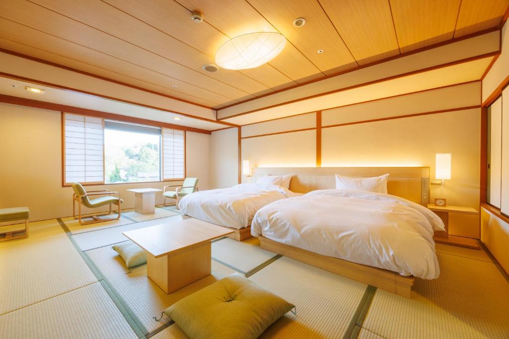 - une chambre avec 2 lits et une table dans l'établissement Hotel Gyokusen, à Matsue