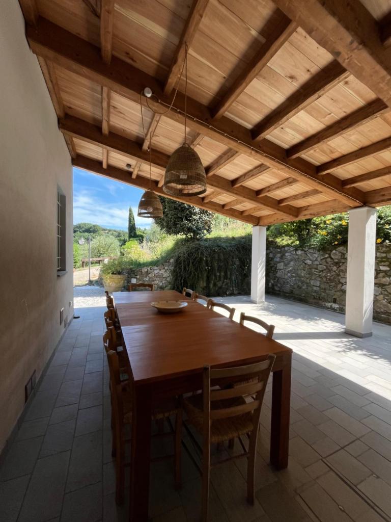 une salle à manger avec une table et des chaises en bois dans l'établissement Villa Prana by Nicola Real Estate, à Corsanico-Bargecchia