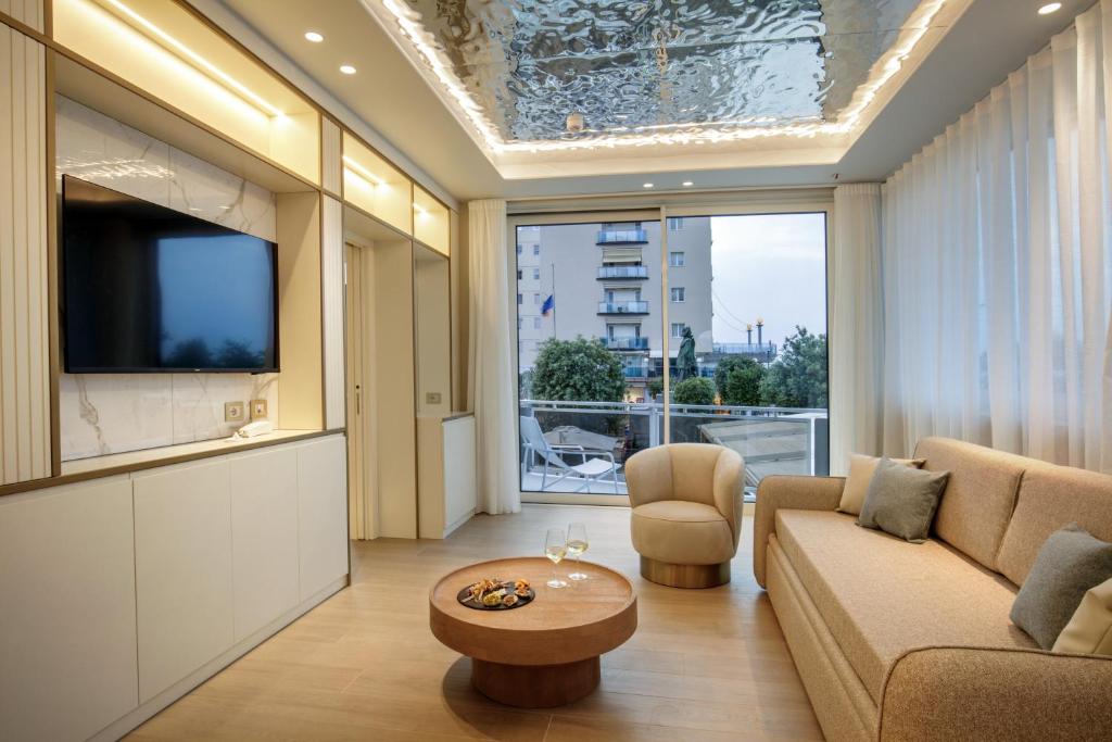 un salon avec un canapé et une télévision dans l'établissement Ambasciatori Suite Hotel, à Sottomarina