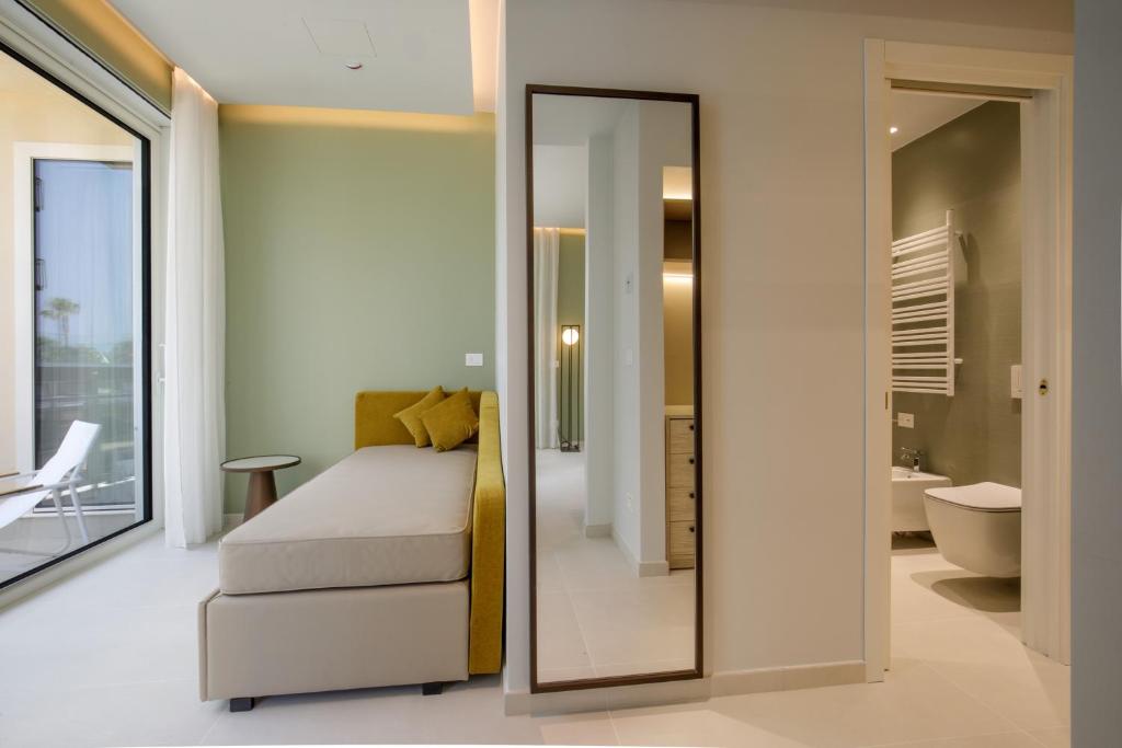 une chambre avec un miroir et un lit et une salle de bain dans l'établissement Ambasciatori Suite Hotel, à Sottomarina 134 autres photos