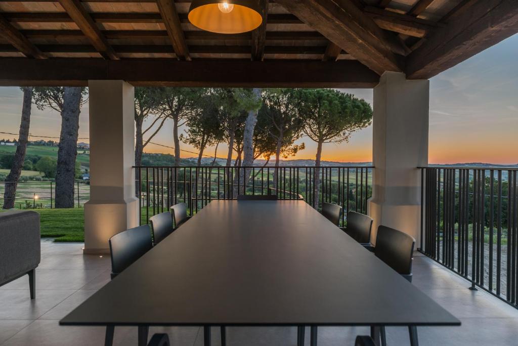 d'une longue table et de chaises sur un balcon avec vue sur le coucher du soleil. dans l'établissement Villa Maracci, à San Savino