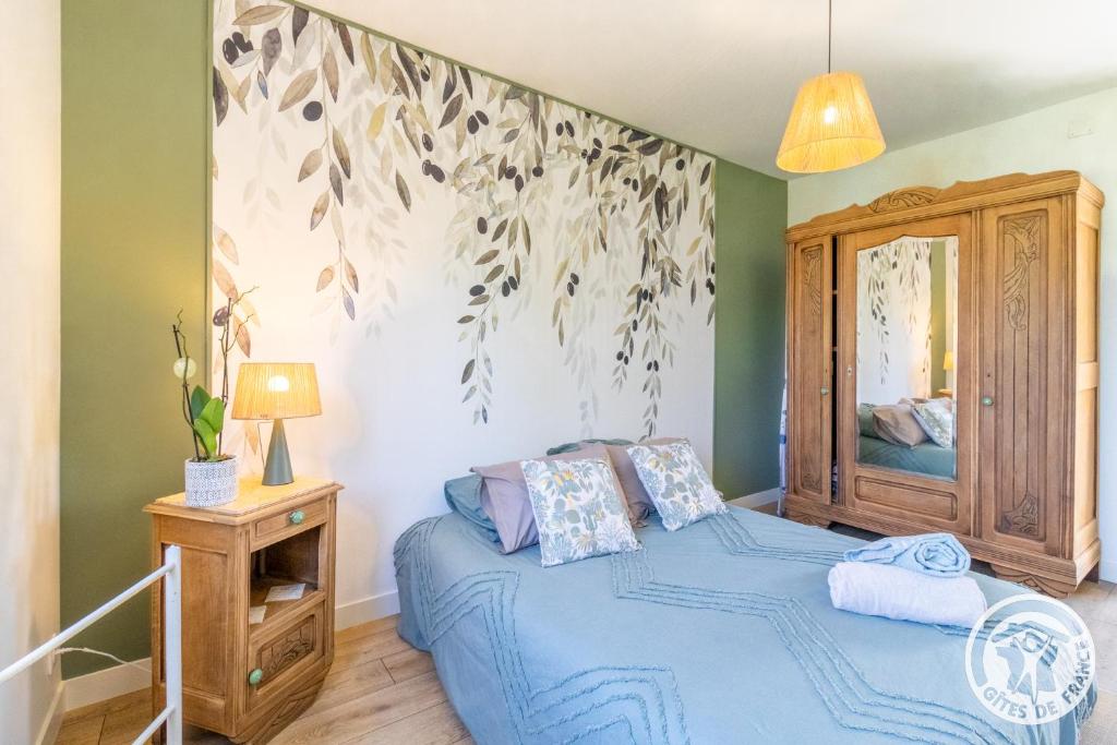 une chambre avec un lit avec une couette bleue dans l'établissement Gîte Ecrin de Verdure Jacuzzi et piscine, à Angrie 37 autres photos