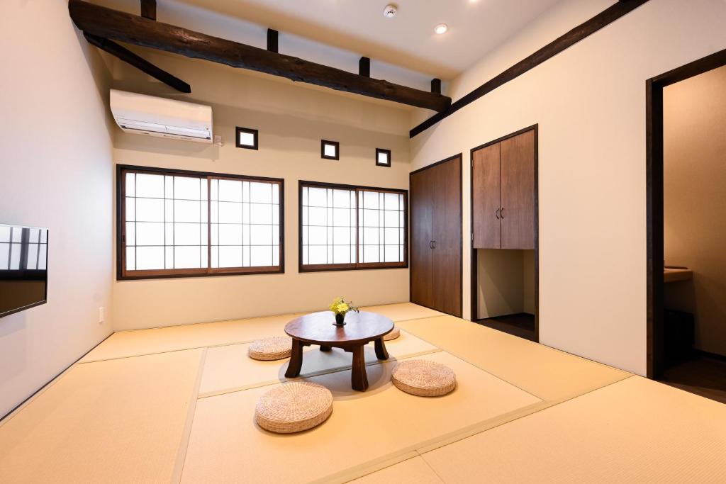 - un salon avec une table et deux tabourets dans l'établissement うり房旅館仲通り うら房, à Kusatsu