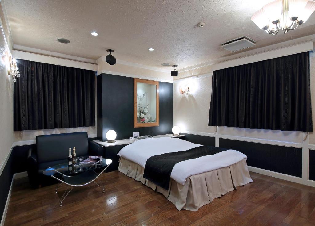 une chambre avec un lit, un bureau et une chaise dans l'établissement Hotel Mio Resort ( Adult Only), à Yokkaichi