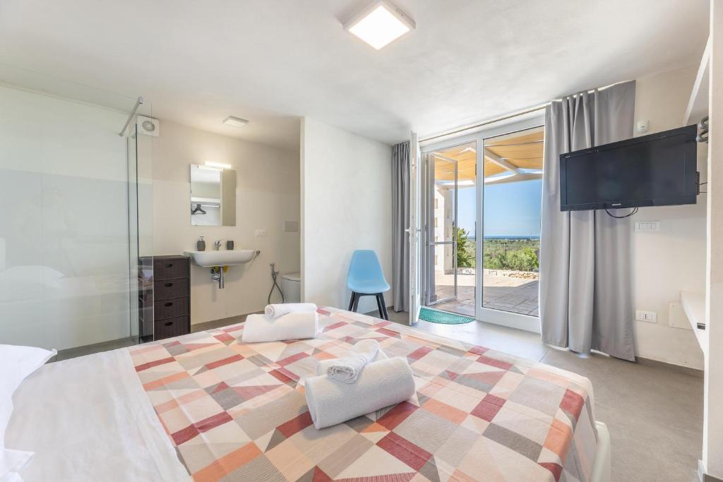 une chambre avec un grand lit et une salle de bain dans l'établissement Villa Alba Chiara, à Serranova 21 autres photos