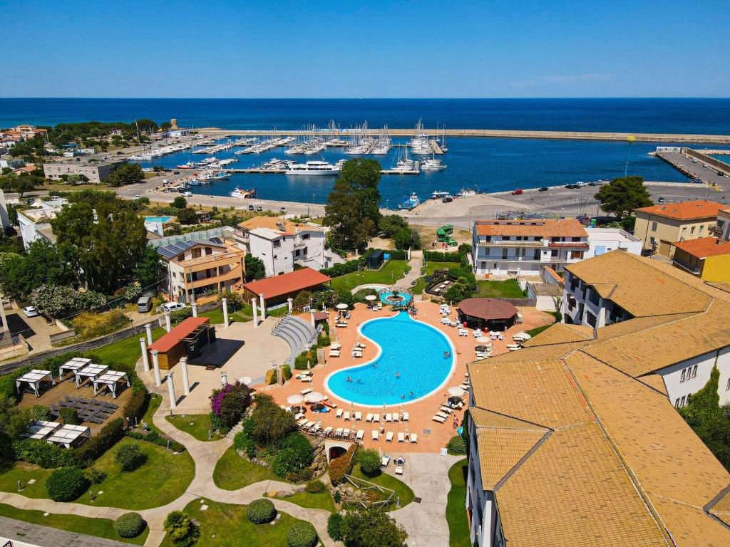 Vue aérienne d'un complexe hôtelier avec piscine et marina dans l'établissement Hotel La Caletta Village, à La Caletta